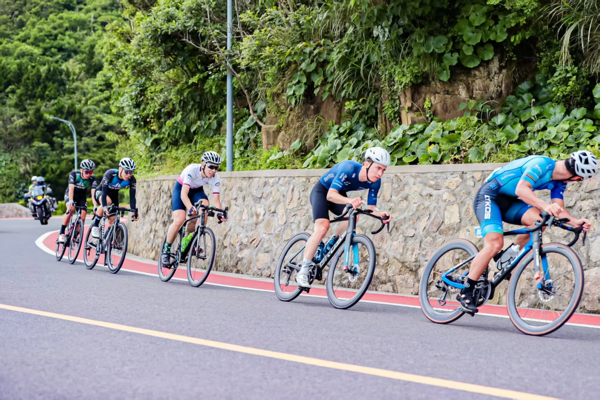 公路车运动员在山路上组成追逐集团